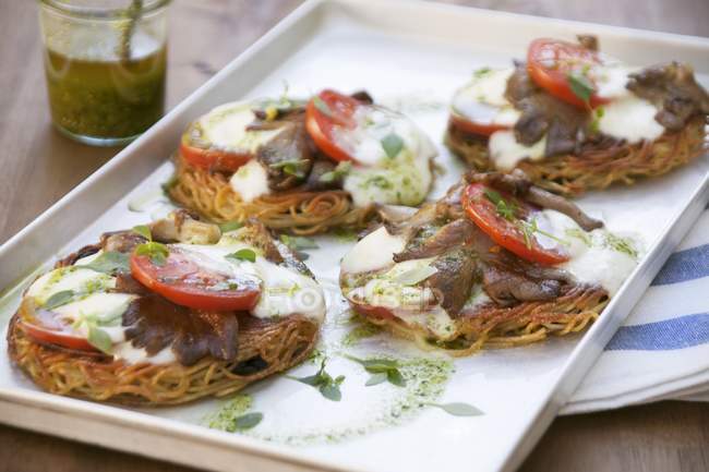 Spaghetti pizzas topped with mushrooms — Stock Photo