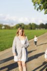 Woman walking on dirt road — Stock Photo