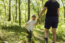 Boy (2-3) walking in forest with mother — Stock Photo