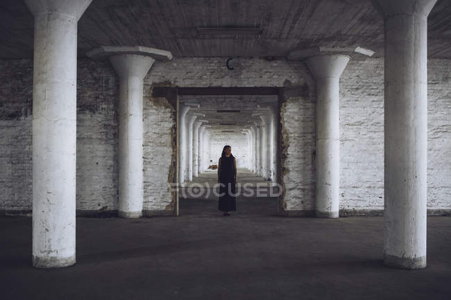Woman standing in old factory — Stock Photo