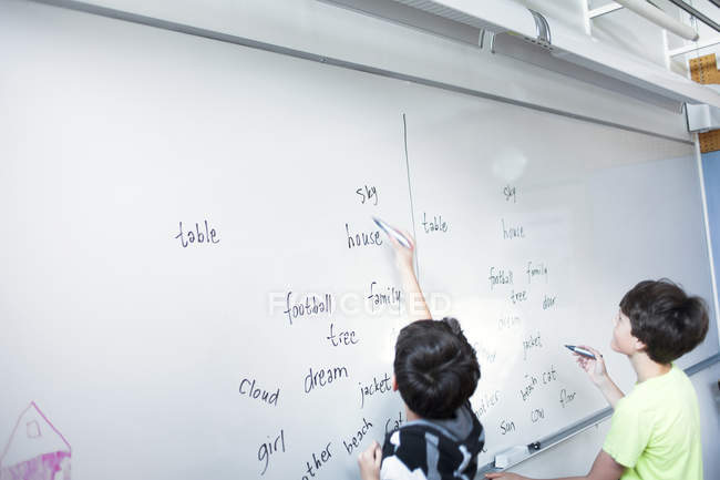 Schoolboys writing spellings — Stock Photo