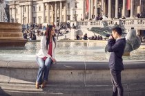 Woman on fountain edge posing for camera — Stock Photo