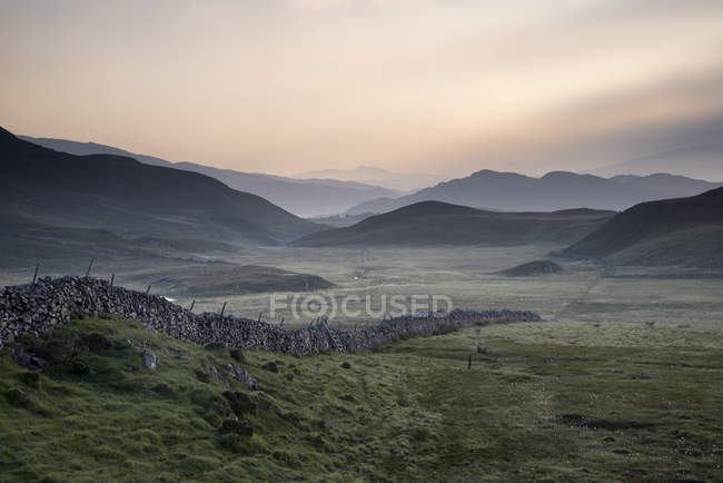 Countryside fields towards misty Snowdonia mountain — Stock Photo