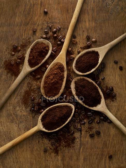 Wooden spoons with ground coffee on rustic background. — Stock Photo