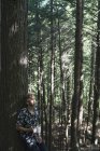 Young man standing in a forest with a cup of coffee, Little River State Park; Waterbury, Vermont, United States of America — Stock Photo