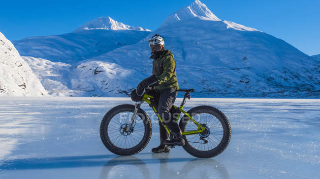 Man riding fatbike across frozen Portage Lake in mid-winter in South-central Alaska, United States of America — Stock Photo