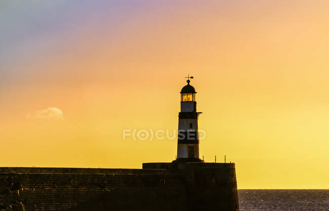 Phare avec ciel doré au coucher du soleil ; Seaham, Durham, Angleterre — Photo de stock
