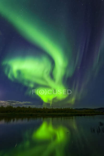 Bright green aurora swirling over Harding Lake with reflections, Interior Alaska in autumn; Fairbanks, Alaska, United States of America — Stock Photo