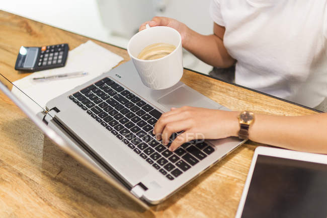 Image recadrée de la jeune femme travaillant avec un ordinateur portable — Photo de stock