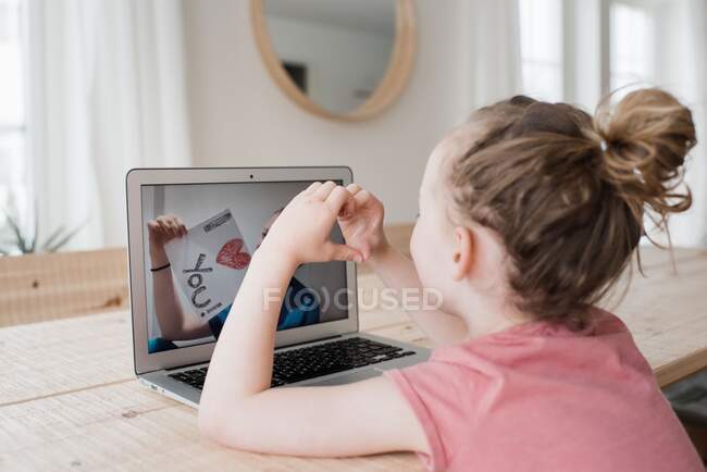 Girl talking to a nurse on a video call with an I love you sign — Stock Photo