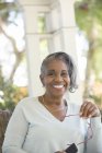 Portrait of happy senior woman holding eyeglasses outdoors — Stock Photo