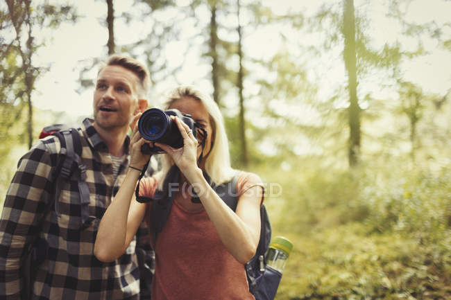 Couple hiking and photographing woods with digital SLR camera — Stock Photo