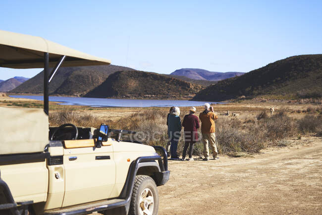 Senior friends on safari watching wildlife in distance — Stock Photo