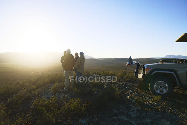 Safari tour group enjoying idyllic sunrise from hill South Africa — Stock Photo