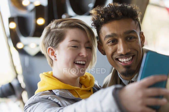 Smiling young couple taking selfie with camera phone — Stock Photo