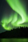 Luzes setentrionais etéreas sobre lago na floresta boreal, arredores de Yellowknife, Territórios do Noroeste, Canadá — Fotografia de Stock