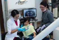 Female dentist explaining about teeth model in clinic — Stock Photo