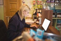 Woman using laptop and writing on notepad in office — Stock Photo
