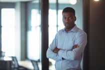 Portrait of businessman with arms crossed in office — Stock Photo