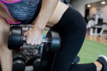 Woman lifting dumbbells at gym — Stock Photo