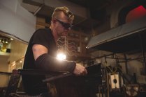 Glassblower forming and shaping molten glass at glassblowing factory — Stock Photo