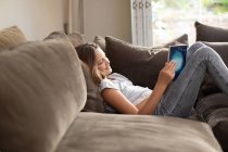 Side view of a tween Caucasian girl reading in sitting room — Stock Photo