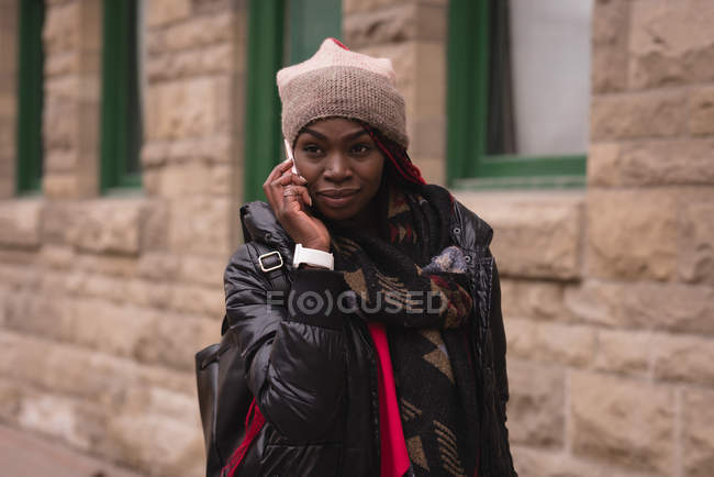 Young woman talking on mobile phone in city street — Stock Photo