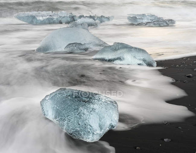 Icebergs on black volcanic beach.  Beach of the north atlantic near the glacial lagoon Joekulsarlon and glacier Breithamerkurjoekull in the Vatnajoekull NP.europe, northern europe, iceland,  February — Stock Photo