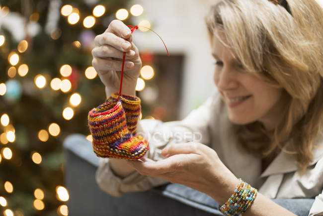 Woman holding pair of knitted booties — Stock Photo