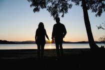 Couple holding hands on shore — Stock Photo