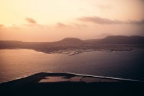 Aerial view to beautiful river and town in sunset lights. — Stock Photo