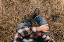 Man sitting on straw grass — Stock Photo