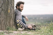 Male photojournalist sitting with camera — Stock Photo