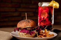 Tasty burger with french fries on plate and glass of coke — Stock Photo