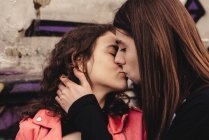 Long haired man hugging and kissing woman near train — Stock Photo