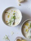 Taças de sopa de creme de espargos gostoso com queijo e ervas no fundo branco — Fotografia de Stock