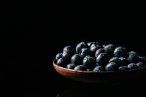 Fresh blueberries on wooden bowl on table — Stock Photo