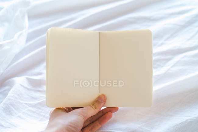Hand holding empty notepad — Stock Photo