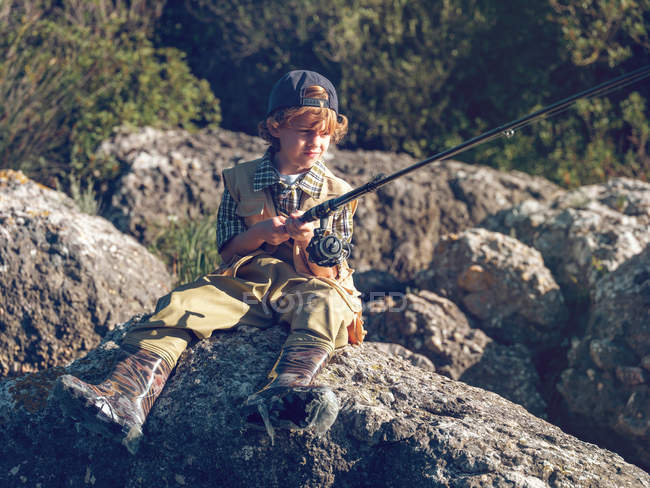 Young boy sitting and fishing — Stock Photo