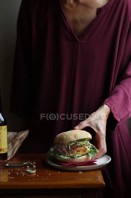 Close-up de mulher desfrutando de cerveja e hambúrguer vegetariano — Fotografia de Stock