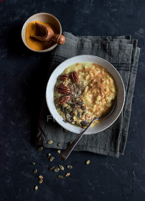 Oatmeal porridge with turmeric in bowl on dark background — Stock Photo