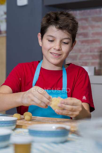 Cheerful teen concentrated working with pastry — Stock Photo