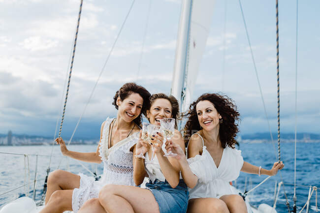 Cheerful friend with wine having fun on yacht — Stock Photo