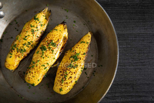 From above endives with hollandaise sauce au gratin in pan decorated with herbs — Stock Photo