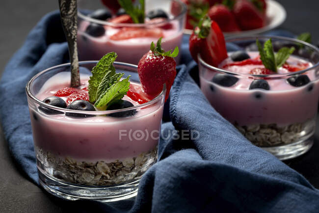 Homemade yogurt with strawberries, blueberries and cereals with dark background and sunlight.Healthy food concept.Vegan food — Stock Photo