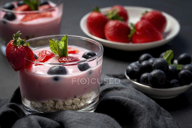Homemade yogurt with strawberries, blueberries and cereals with dark background and sunlight.Healthy food concept.Vegan food — Stock Photo