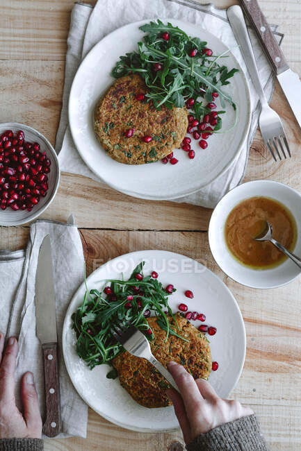 De cima cortado pessoa irreconhecível comer deliciosos hambúrgueres vegan na mesa de madeira — Fotografia de Stock