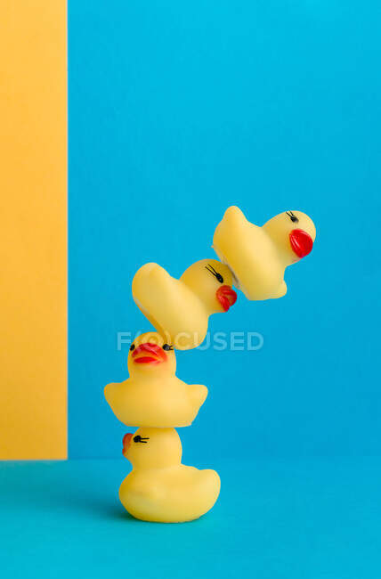 Set of cute rubber ducklings and duck mom toys placed on bright blue and yellow background — Stock Photo