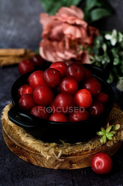 Bowl with fresh sweet plums served on black table — Stock Photo