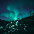 Scenic view of Northern lights over waterfall, Lofoten, Norway — Stock Photo
